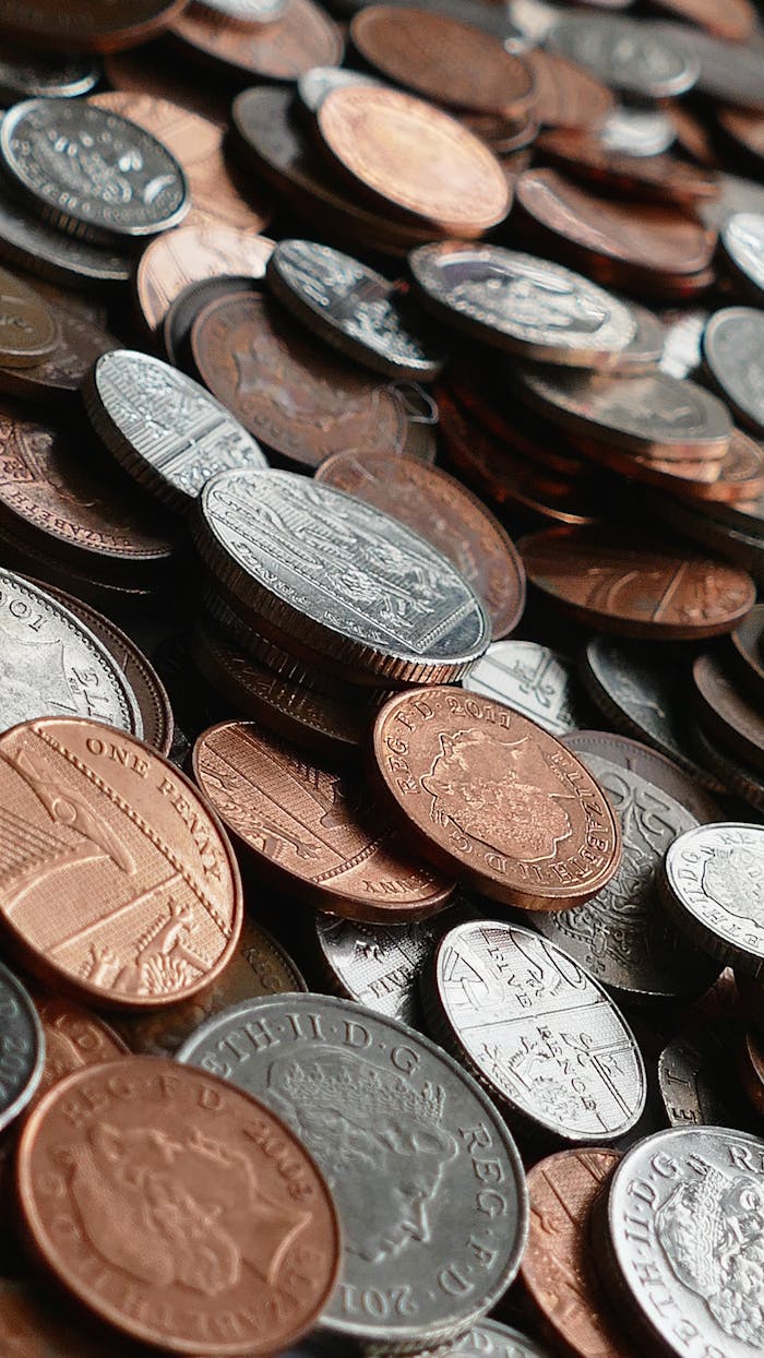 our-journey-03 Close-up of various international coins in a pile, showcasing different currencies and designs.
